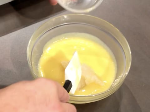 Ajout de la gélatine hydratée et fondue dans la préparation à base de Champagne, jus de citron, jaunes d'oeufs et sucre