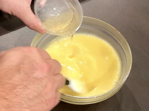 Ajout du Champagne dans la préparation à base de Champagne, jus de citron, jaunes d'oeufs et sucre