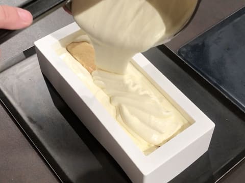 De la mousse Champagne est versée sur l'insert, dans le moule à bûche en silicone