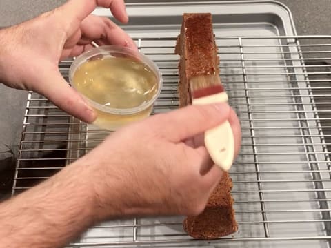 Punchage du cake avec le sirop et un pinceau pâtissier