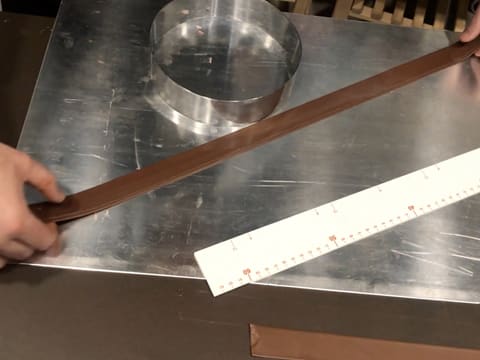 La bande de chocolat au lait est attrapée par les deux extrémités avec les deux mains