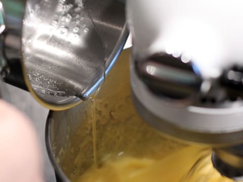 Le sucre cuit est versé dans la cuve du batteur qui contient les œufs battus