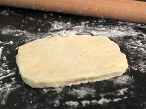 Le beurre mélangé à la farine est façonné en un rectangle sur le plan de travail fariné