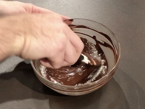 Le beurre de cacao Mycryo est incorporé au chocolat noir fondu dans le saladier, à l'aide de la spatule maryse