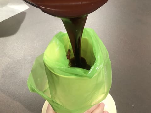 La ganache caramel est versée dans une poche à douille