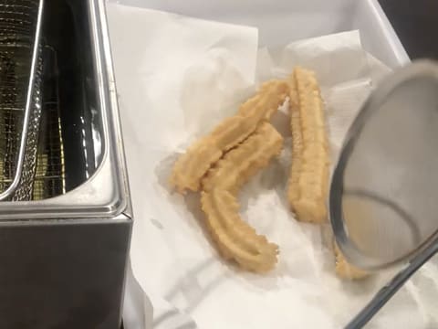 Les churros sont égouttés sur du papier absorbant