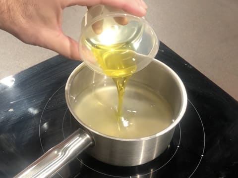 Ajout de l'huile d'olive dans la casserole qui contient l'eau et le jus de yuzu