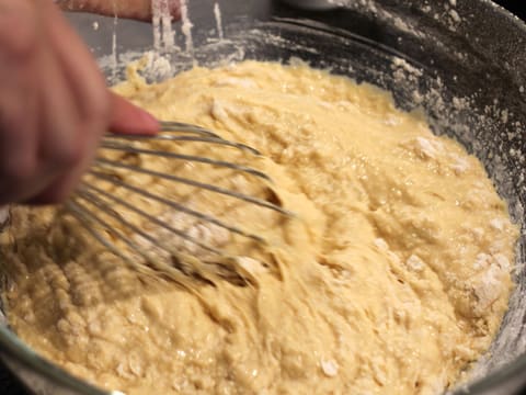 La farine, les oeufs, le sucre et le lait sont mélangés au fouet dans le saladier