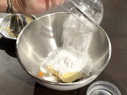 Ajout du sucre glace sur le beurre pommade et les zestes d'orange, dans le cul de poule