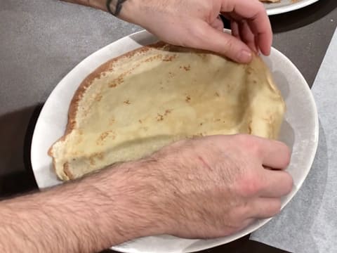 Une crêpe est placée sur une assiette