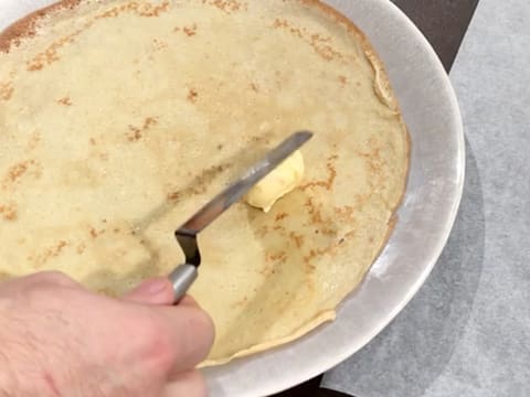 Une noix de beurre d'orange est déposée sur la crêpe