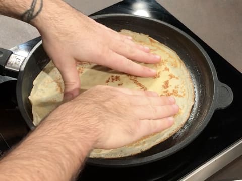 Une crêpe est déposée dans la poêle