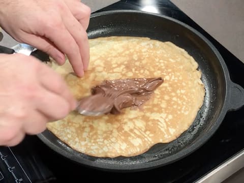 Une cuillère à soupe de pâte à tartiner est déposée au centre de la crêpe