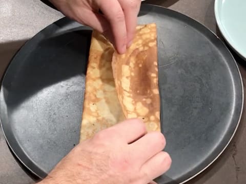 L'autre côté de la crêpe est replié vers le milieu, de façon à former un pliage en portefeuille