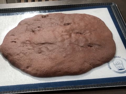 La pâte à biscuit chocolat est cuite sur le tapis de cuisson en silicone, le tout posé sur le plan de travail