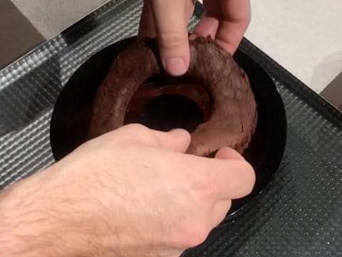 Un anneau de biscuit chocolat est déposé dans le moule silicone, sur la ganache chocolat/tonka