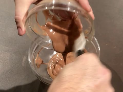 Le mélange de chocolats fondus est versé dans le bol contenant la préparation faite de Gianduja et de purée d'amande blanche