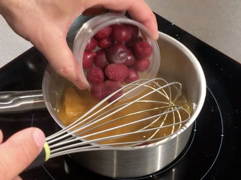 Ajout des griottes surgelées dans la casserole qui contient la purée de mangue