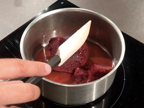 Ajout de la purée de griotte dans la casserole qui contient la purée de fraise, le sirop de glucose et le sucre inverti et qui est placée sur la plaque de cuisson