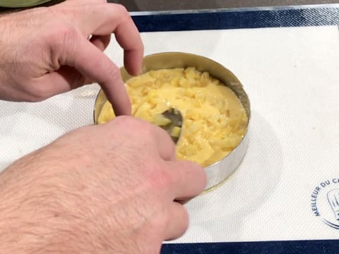 La brunoise de fruits est répartie sur le crémeux passion/pabana avec une petite cuillère, dans le cercle à mousse placé sur le tapis de cuisson en silicone