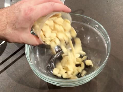 Les pistoles de chocolat blanc sont versées dans un saladier sur le plan de travail