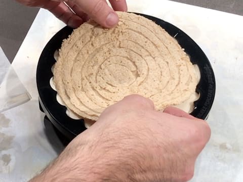 Le biscuit dacquoise est déposé sur le bavarois chocolat blanc, vanille, jasmin dans le moule en silicone