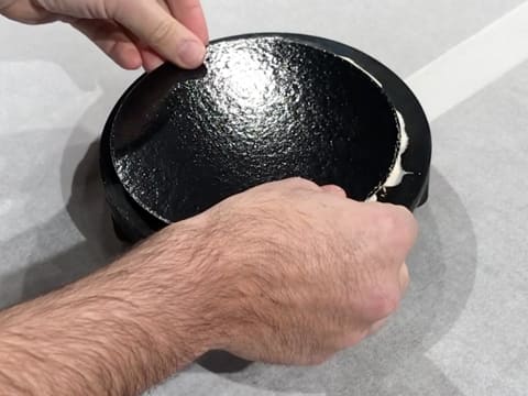 Un support à gâteau rond est posé sur l'entremets qui est dans le moule silicone