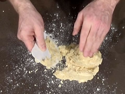 La pâte est débarrassée à l'aide d'une corne, sur un plan de travail fariné