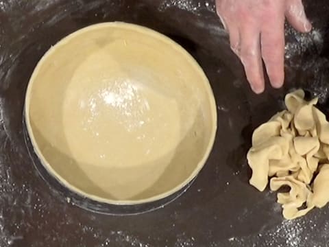 La pâte est bien foncée dans le cercle à mousse, et l'excédent de pâte qui a été retiré est mis de côté