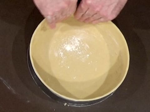 La pâte qui est foncée dans le cercle à mousse, est plaquée contre ce dernier, à l'aide des doigts