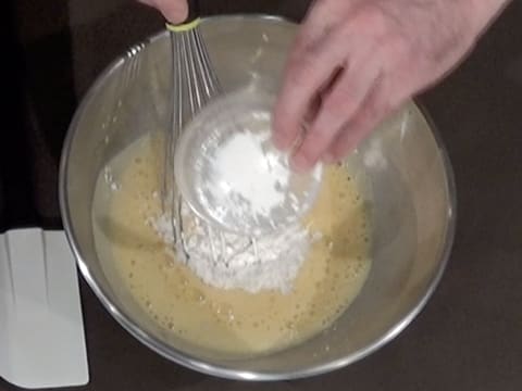 Ajout de la poudre à crème sur les oeufs et le sucre blanchis ensemble, dans le cul de poule
