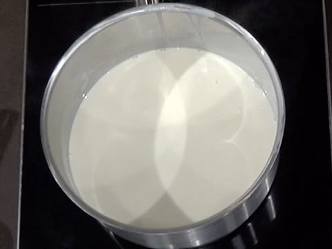 La moitié du mélange crème et lait, est chauffé dans la casserole, sur la plaque de cuisson