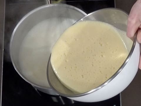 La préparation contenue dans le cul de poule, est versée dans le lait bouillant, dans la casserole
