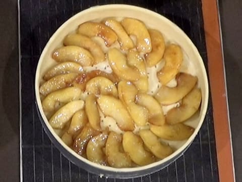 Les lamelles de pomme rôties sont disposées, sur une seule couche, sur le fond de pâte dans le cercle à mousse