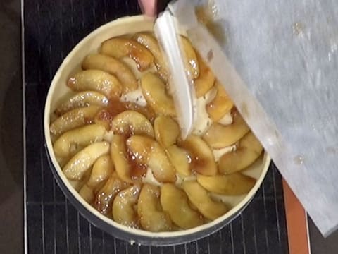 Ajout du jus de cuisson caramélisé sur les lamelles de pomme disposées dans le fond de pâte