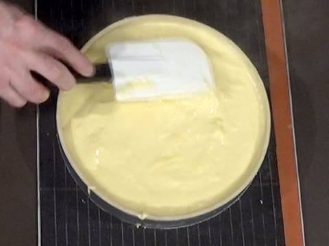La surface de la crème qui est dans le fond de pâte, est lissée à l'aide d'une spatule maryse