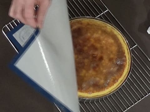 Le tapis de cuisson en silicone est retiré de la surface du flan