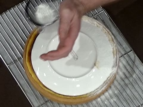 Le tour du flan qui est recouvert d'une assiette retournée, est saupoudré de sucre glace