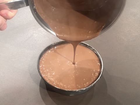 La crème au chocolat est versée dans le moule à manqué rond et arrive au ras bord de celui-ci