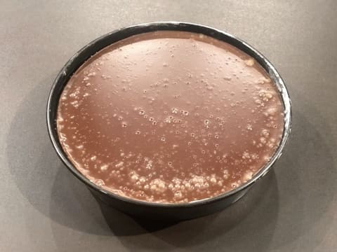 Formation d'une croûte à la surface de la crème au chocolat qui se trouve dans le moule à manqué rond