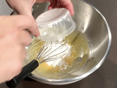 Ajout de la poudre à crème sur le mélange jaunes d'oeufs et sucre, dans le cul de poule