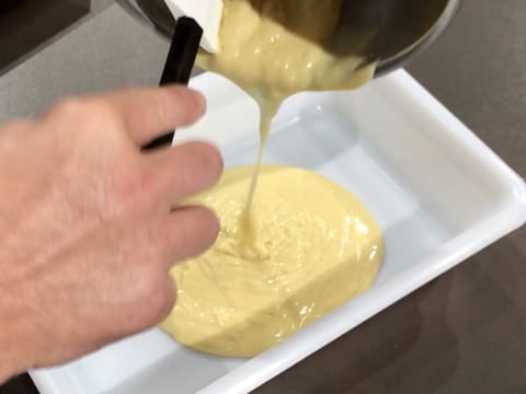 La crème obtenue dans la casserole est versée dans un bac alimentaire