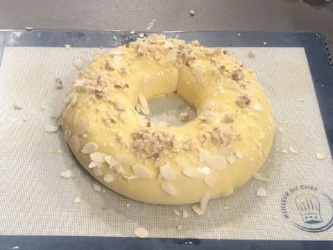 Obtention de la pâte à brioche gonflée, en forme de couronne et qui est parsemée de crumble aux amandes et d'amandes effilées