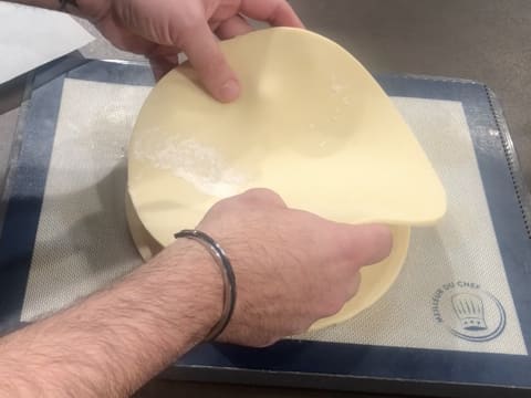 Le second disque de pâte feuilletée inversée est retourné sur le premier qui se trouve sur la plaque à pâtisserie recouverte du tapis de cuisson en silicone