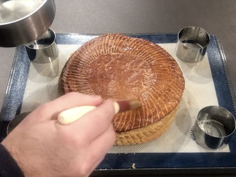 À l'aide d'un pinceau à pâtisserie toute la surface de la galette des rois est recouverte d'un sirop à 30° baumé