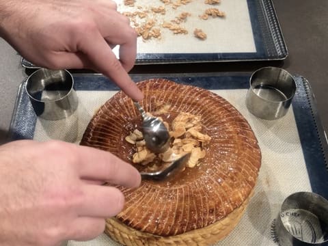 Des amandes effilées caramélisées sont déposées au centre de la galette des rois