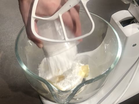Ajout du sucre glace sur le beurre pommade dans la cuve du batteur qui est muni de l'accessoire feuille