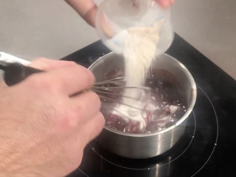 Le mélange pectine NH nappage et sucre en poudre est versé dans la casserole qui contient la purée de cassis et les myrtilles