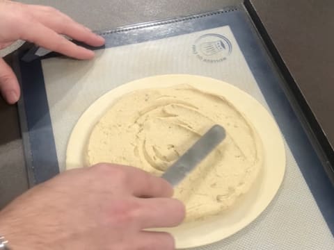 La surface de la crème frangipane est lissée avec une petite spatule métallique coudée