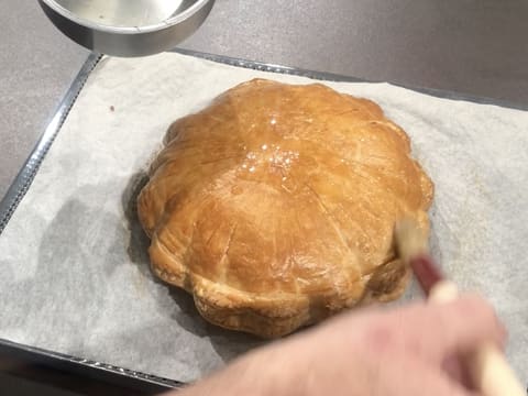 Toute la surface de la galette des rois est lustrée de sirop avec le pinceau pâtissier